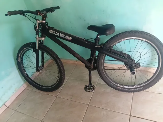 Cama de solteiro com colchão e uma bicicleta 