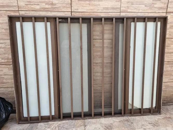 Janela de alumínio completa com vidros transparentes, grade e tela mosquiteiro