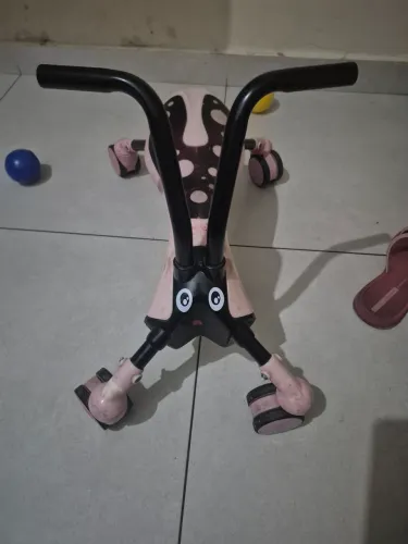 andador infantil ScrambleBug com design de besouro rosa e preto.