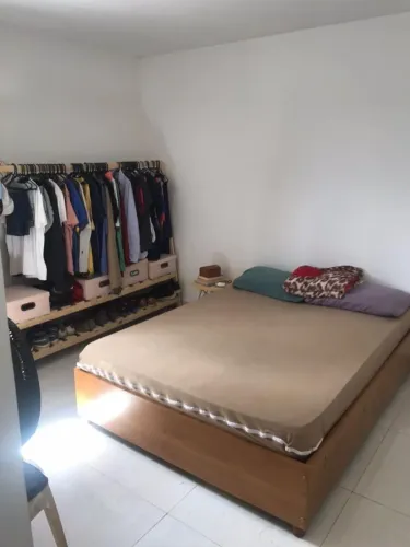Cama e arara de roupas