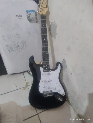 Guitarra strato com amplificador, fio, palheta e faixa de suspensão