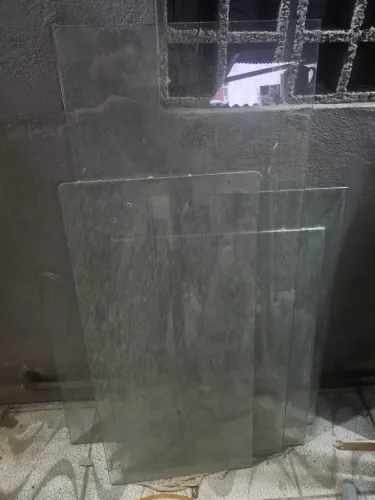 Mesas de vidro em L desmontadas com a várias, varios tampos