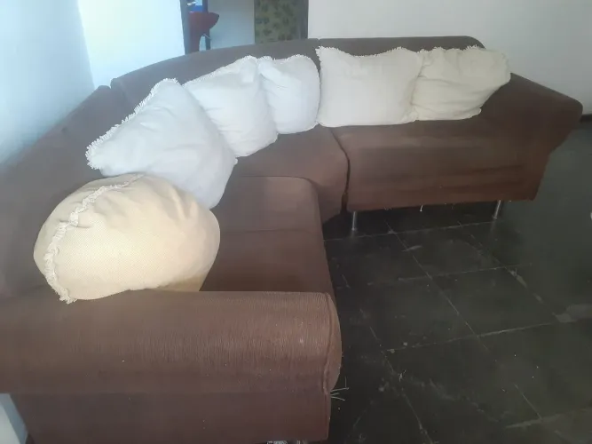Vendo sofá em tecido com almofadas.