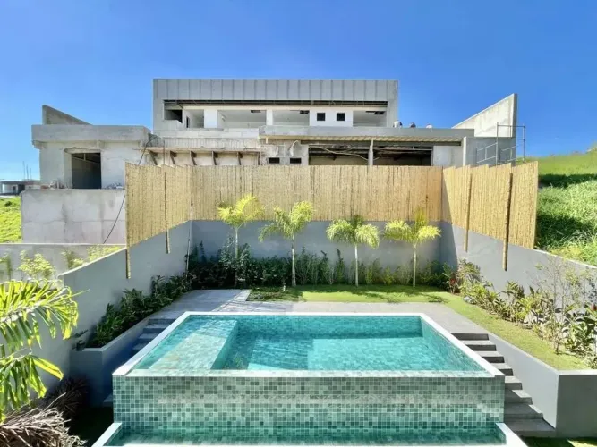 Casa com piscina iluminada, com prainha, revestida em pedra Hijau, borda infinita e solari