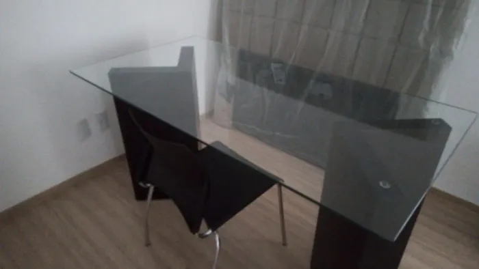 Mesa de vidro com duas cadeiras.