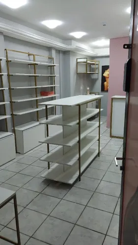 Ilha expositora para loja na cor branca com estrutura dourada