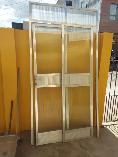 Porta de alumínio com vidro, chave e maçaneta.