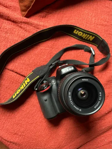 Nikon D5100 com lente 18-55 mm, duas baterias, carregador, filtros e acessórios