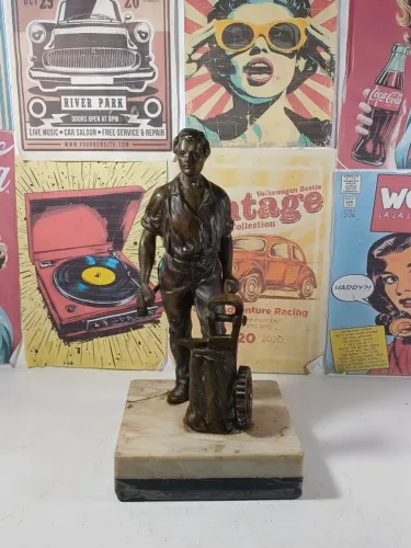 escultura antiga em bronze de um ferreiro sobre uma base de mármore