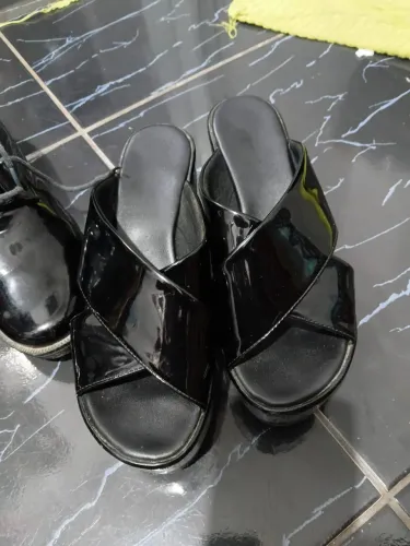 Essas sandálias plataformas pretas de verniz com tiras cruzadas modelos da marca Zaxy.
