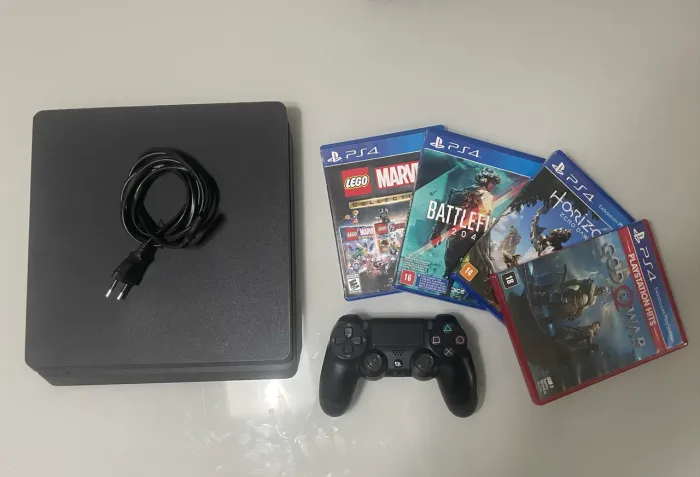 ps4 slim usado, com 1TB de armazenamento, quatro jogos e um controle