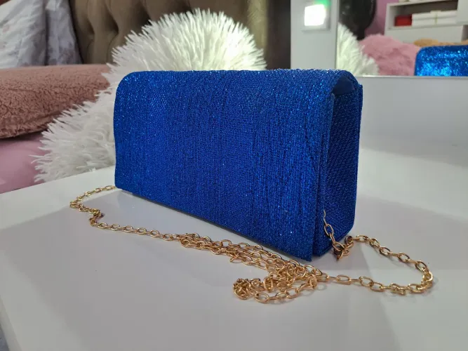 Bolsa clutch feminina azul cintilante com alça de corrente dourada.