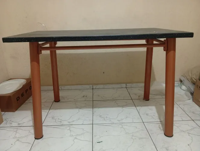 Fogão, estante, colchonete, botijão e mesa.