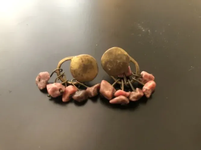 Disco dourado envelhecido, pedras brutas rosa.