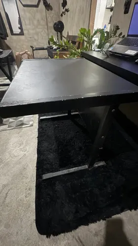 Mesa grande de escritório em L preta com estrutura metálica