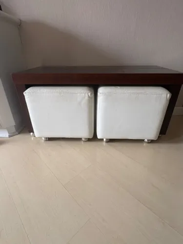 Mesa aparadora em madeira castanho com dois pufs branco em courino