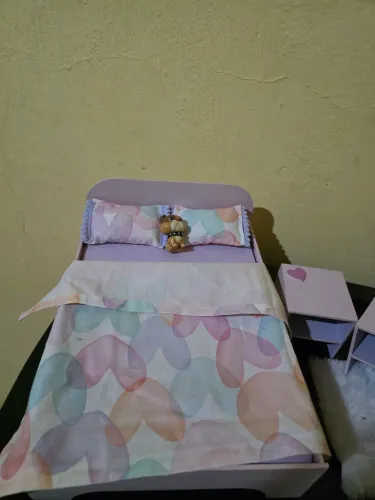 Cama de boneca com detalhes fofos e roupa de cama