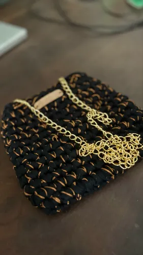 Bolsa de crochê em fio de malha prêmio com detalhes dourados