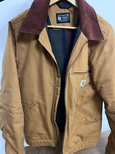 Carhartt modelo Detroit de ajuste relaxado na cor marrom com gola de veludo cotelê.