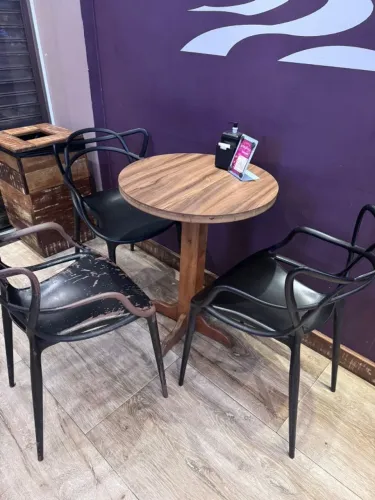 Mesa baixa de madeira e três cadeiras de plástico rígido
