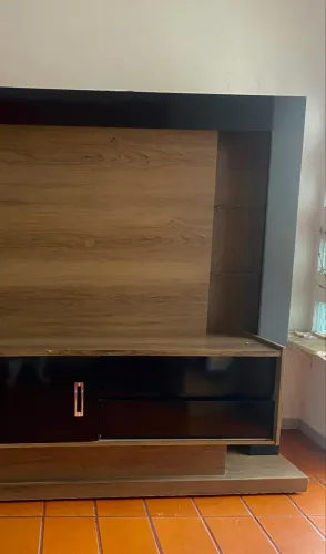 Estante para TV com painel e espaço de decoração.