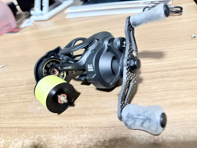 Carretilha PISCIFUN CARBON XCS - ESQUERDA | KNOBS GOMEXUS + ROLAMENTOS DE CERÂMICA