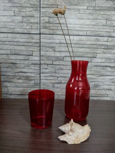 Jarra e copo vermelhos em vidro