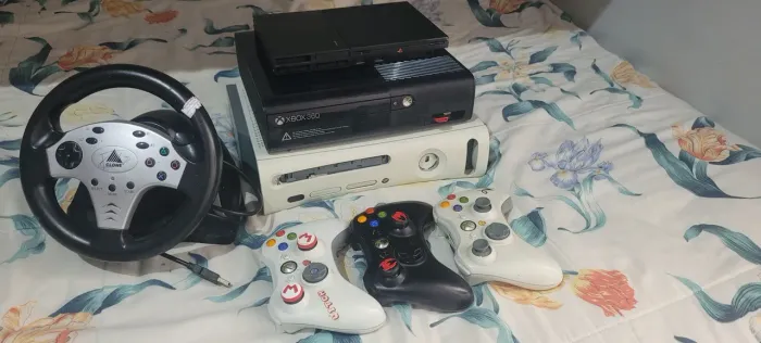 3 Consoles dois Xbox 360 um é o fat outro é Super Slim e ps2 n lê disco junto e volante