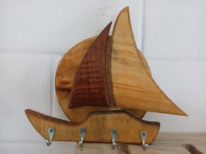 Porta chaves em formato de barcos entalhado na madera.