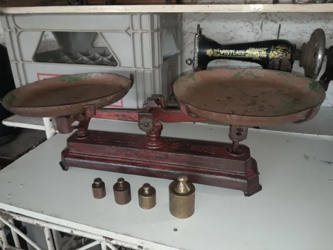 Balança antiga de dois pratos com pesos de bronze 