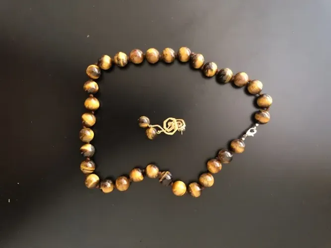 Conjunto colar e brincos tipo olho de tigre. Dourado, profundo, sem esforço.