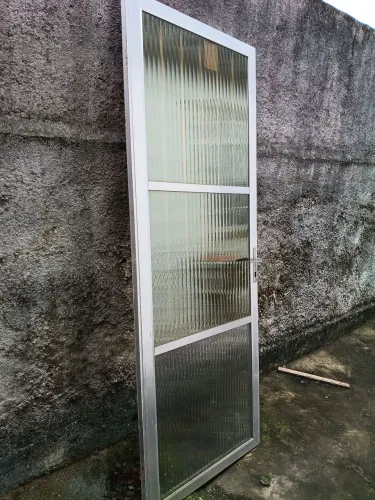 Porta de alumínio com vidro canelado o 2vde cima e um pouco mais escuro de que o debaixo