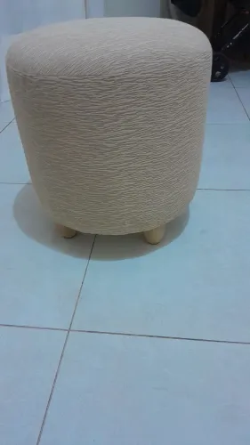 01 pufe redondo em tecido creme texturizado com pés em madeira