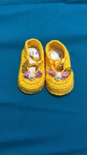 Sapatinhos de crochê amarelo com detalhes florais