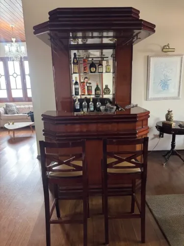 Bar de madeira antigo com iluminação e banquetas - ótimo estado