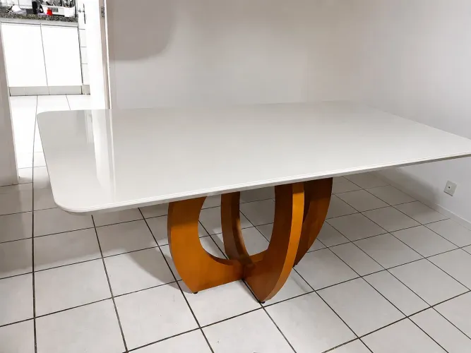 Vendo mesa com base central de madeira curvada e tampo leitoso