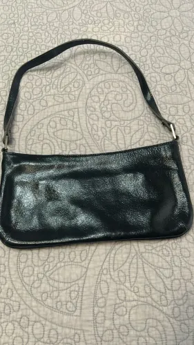 Bolsa Média Couro Preto com detalhes dourados.