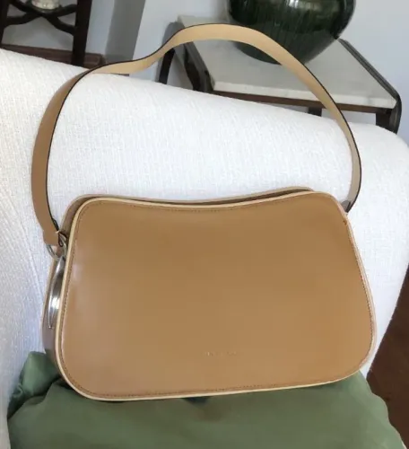 Elegante Bolsa de Ombro, em Couro Legítimo caramelo com viés bege e detalhes metálicos.
