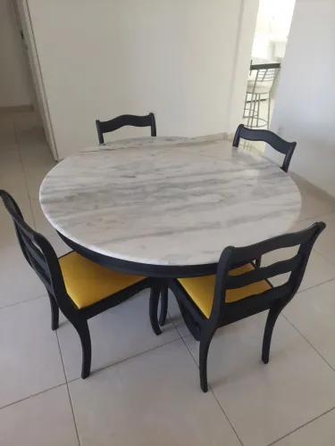 Mesa redonda estilo clássico com quatro lugares e tampo de mármore branco.