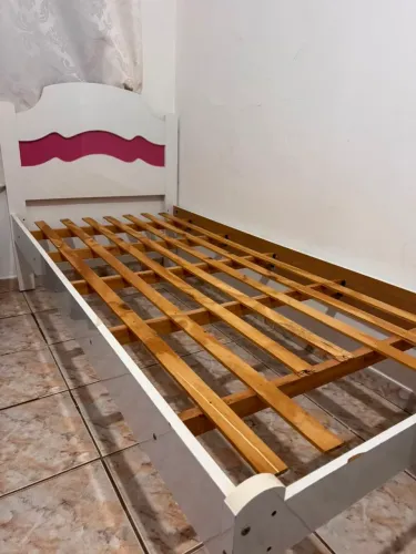 Cama de solteiro branca com detalhes em rosa