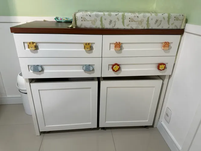 Cômoda infantil com quatro gavetas e dois baús com rodinhas. Cabideiro branco pra compor