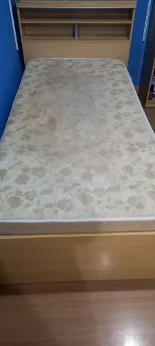 Cama de madeira com colchão e criado mudo