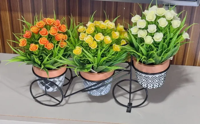 Suporte decorativo em formato de bicicleta com vasos e flores artificiais coloridos