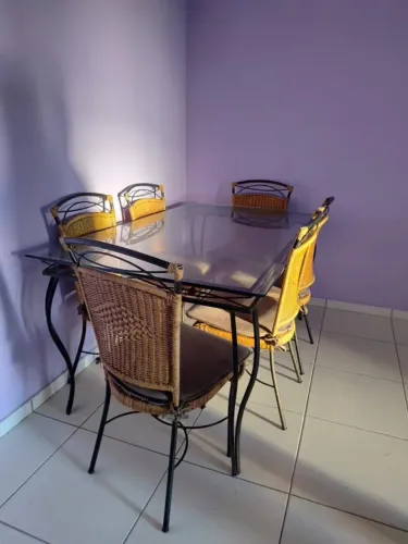 Mesa retangular, tampo de vidro e estrutura de metal rustico, seis cadeiras de vime.