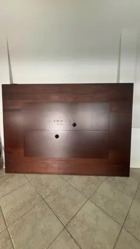 Painel de madeira para TV, cor tabaco/amadeirado, com passagem para cabos.