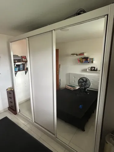 Armário branco com dois espelhos.