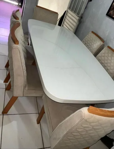 Mesa de 6 cadeiras com vidro quadrado.