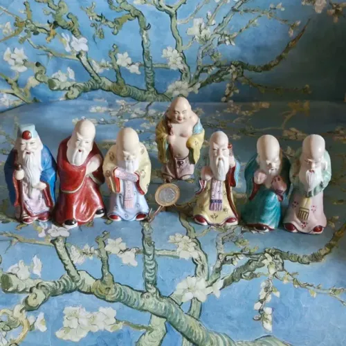 Sete estatuetas com sábios chineses em porcelana esmaltada. 10 cm de altura.Perfeitos.