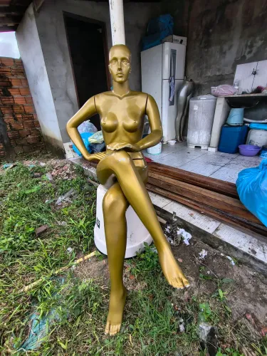Manequim feminino de pose sentando.