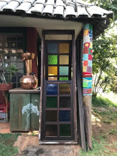 Janela tipo guilhotina em madeira e vidros martelados coloridos